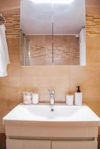 een badkamer met een witte wastafel en een spiegel bij Your Athens Getaway: Stylish Apt in Athens in Athene
