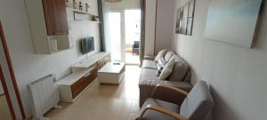 a living room with a couch and chairs and a tv at EnSAN CIPRIAN JARDINES DEL MAR in San Ciprián