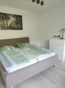 Cama en habitación con pared blanca en Ferienwohnung Lange, en Brilon