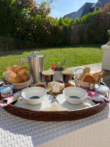 - une table avec un plateau de pain et des bols de nourriture dans l'établissement Les Nord’mandines, à Trouville-sur-Mer