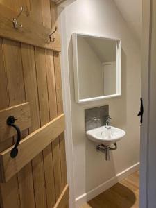 a bathroom with a sink and a mirror at King's Cottage, Wootton, Nr Woodstock. in Wootton