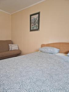 1 dormitorio con 1 cama y 1 sofá en Guesthouse Irac, en Tuzla