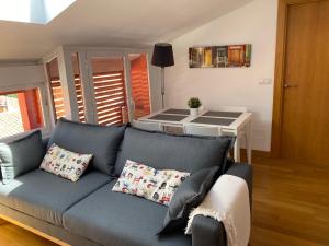 Vivienda turística Los Tejados في سُريا: غرفة معيشة مع أريكة زرقاء وطاولة