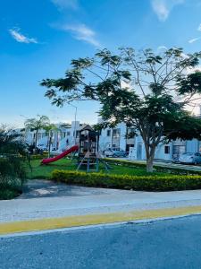 un parque infantil con tobogán en un parque con casas en Renta vacacional, en Playa del Carmen