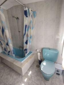 uma casa de banho com um WC azul e um chuveiro em Alquiler vacacional. A de Casas em Sanxenxo