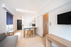 a living room with a flat screen tv on a wall at Poseidon Deluxe Apartments in Kos +46 photos