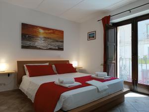 1 dormitorio con 1 cama grande con sábanas rojas y blancas en Le Rose di Maria, en Trapani
