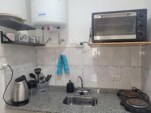 - un comptoir de cuisine avec évier et four micro-ondes dans l'établissement DEPARTAMENTO TEMPORARIO A&F III, à San Fernando del Valle de Catamarca