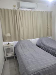 - une chambre avec deux lits à côté d'une fenêtre dans l'établissement DEPARTAMENTO TEMPORARIO A&F III, à San Fernando del Valle de Catamarca