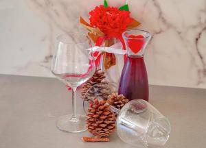 two wine glasses and a vase with flowers and pine cones at Studio apartment Carmen in Rubeši