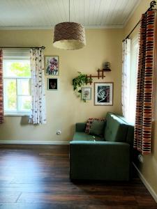 salon z zieloną kanapą i 2 oknami w obiekcie Sallimeister Linda külalistemaja. w mieście Haapsalu