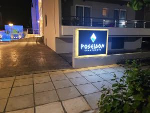 a sign on the side of a building at night at Poseidon Deluxe Apartments in Kos