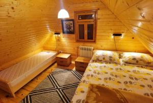 ein Schlafzimmer mit einem Bett in einer Holzhütte in der Unterkunft Mountain Hut Stara Hiša in Kupjak
