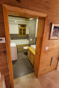 a bathroom with a tub and a sink and a mirror at Mountain Hut Stara Hiša in Kupjak