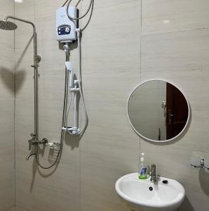 a bathroom with a shower and a sink and a mirror at Cozy Haven furnished apartments in Kampala