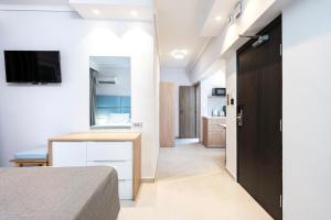 a bedroom with a bed and a desk with a television at Poseidon Deluxe Apartments in Kos