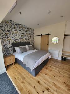 um quarto com uma cama grande e piso em madeira em The Star Inn - Harbottle - Near Rothbury - Northumberland em Morpeth