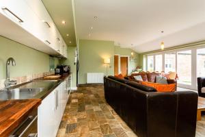 a kitchen and living room with a couch and a table at Cheviot Barn in Chatton