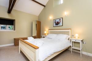 a bedroom with a large white bed with two tables at Cheviot Barn in Chatton