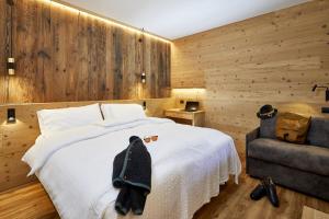 マドンナ・ディ・カンピリオにあるHotel Garni dello Sportivoのベッドルーム(白いベッド1台、椅子付)