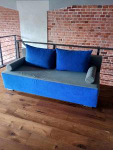 ein blaues Sofa in einem Zimmer mit Ziegelwand in der Unterkunft RedCity LOFT 129 in Żyrardów