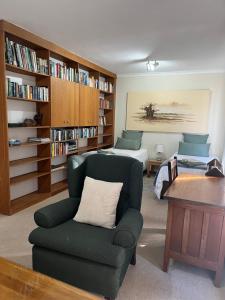 een woonkamer met een bank, een stoel en een bed bij Hermanus Heights Villa in Hermanus