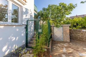 a gate to a house with a stone fence at Apartment Kamila in Krk