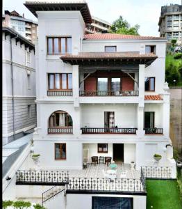 a white house with a balcony in front of it at Hotel Royal Suite Santander in Santander