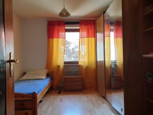 ミュンヘンにあるOktoberfestのベッド1台と窓2つが備わる小さな客室です。