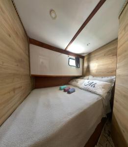 Una cama en una habitación pequeña con dos zapatillas. en göcek yat, en Fethiye