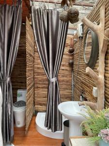a bathroom with a shower curtain and a sink at Phuket Signature Glamping in Rawai Beach