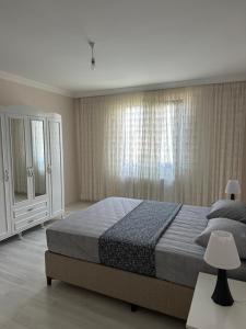 ein Schlafzimmer mit einem großen Bett und einem Fenster in der Unterkunft BLUE FEAST GARDEN KONAKÖNÜ in Araklı
