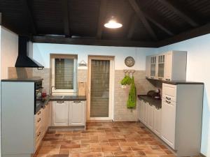 eine Küche mit weißen Schränken und Fliesenboden in der Unterkunft Woodrock Villa in Sarajevo