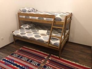 2 Etagenbetten in einem Zimmer mit einem Teppich in der Unterkunft Woodrock Villa in Sarajevo