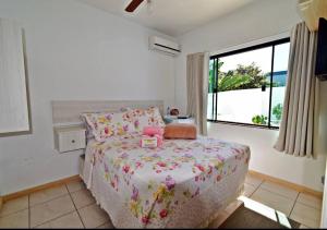 1 dormitorio con cama y ventana grande en Pousada Enseada dos Golfinhos, en Bombinhas