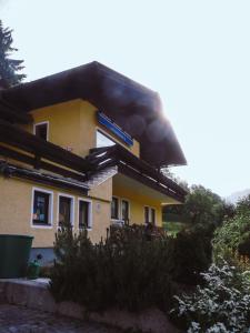 una casa amarilla con humo saliendo de ella en Haus Wasserbauer, en Mühlbach am Hochkönig