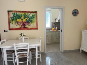 een keuken met een witte tafel en een schilderij aan de muur bij Villa Dei Fiori in Locorotondo