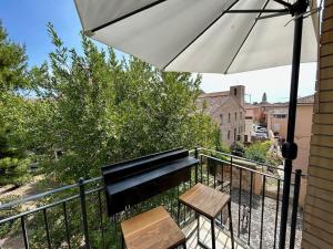 un balcone con panchina e ombrellone di - Chalet Urbano - a Fano
