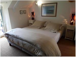1 dormitorio con 1 cama blanca grande y 2 mesitas de noche en Le Pilori en Saint-Jacut-les-Pins