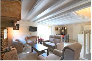 sala de estar con sillones y TV en Le Pilori en Saint-Jacut-les-Pins