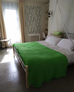 a bedroom with a green blanket on a bed at Infinito in Aguadulce