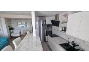a kitchen and living room with white cabinets and a table at Infinito in Aguadulce