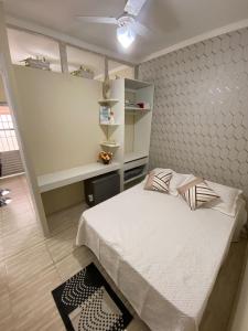 a bedroom with a large bed and a shelf at Studio - Sol & Mar - 300 metros da praia do Canto do Forte - WI FI e ESTACIONAMENTO gratuito - 50 metros da avenida dos barzinhos in Praia Grande