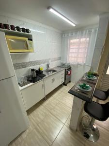 a kitchen with a sink and a counter in it at Studio - Sol & Mar - 300 metros da praia do Canto do Forte - WI FI e ESTACIONAMENTO gratuito - 50 metros da avenida dos barzinhos in Praia Grande