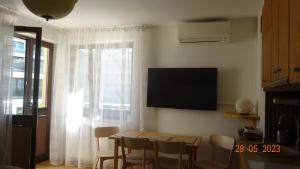 Una sala de estar con una mesa y un televisor en la pared. en Apartament Comfort Kahlberg, en Krynica Morska 22 fotos más