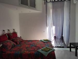een slaapkamer met een rood bed en een raam bij CasaMicia in Gallese