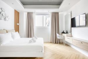 Habitación blanca con cama y TV en Kallirrois 89 Suite, en Atenas