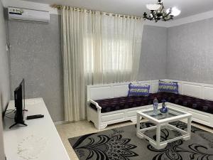 a living room with a couch and a tv at Le bien être in Kelibia