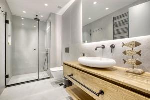 ein Bad mit einem Waschbecken und einer Dusche in der Unterkunft Kallirrois 89 Suite in Athen