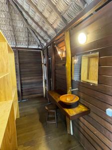 a bathroom with a sink and a wooden wall at Atins Beach Chalés in Atins +118 photos
